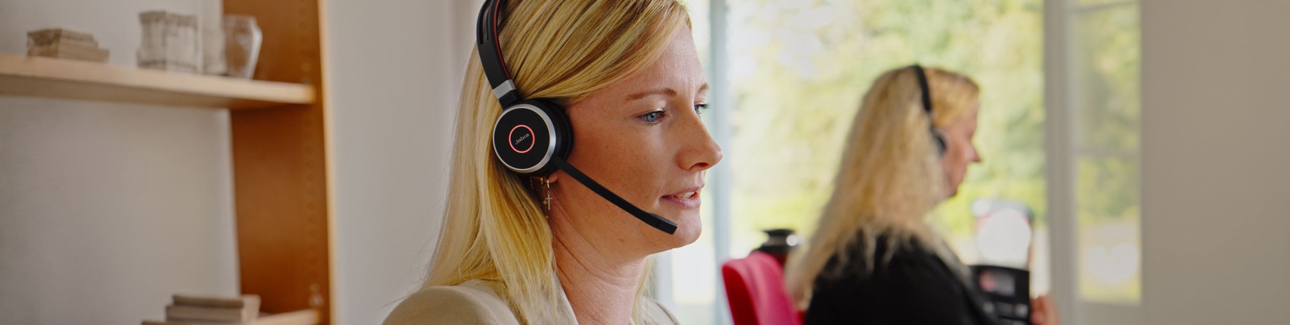 Blonde Frau mit Headset im Büro